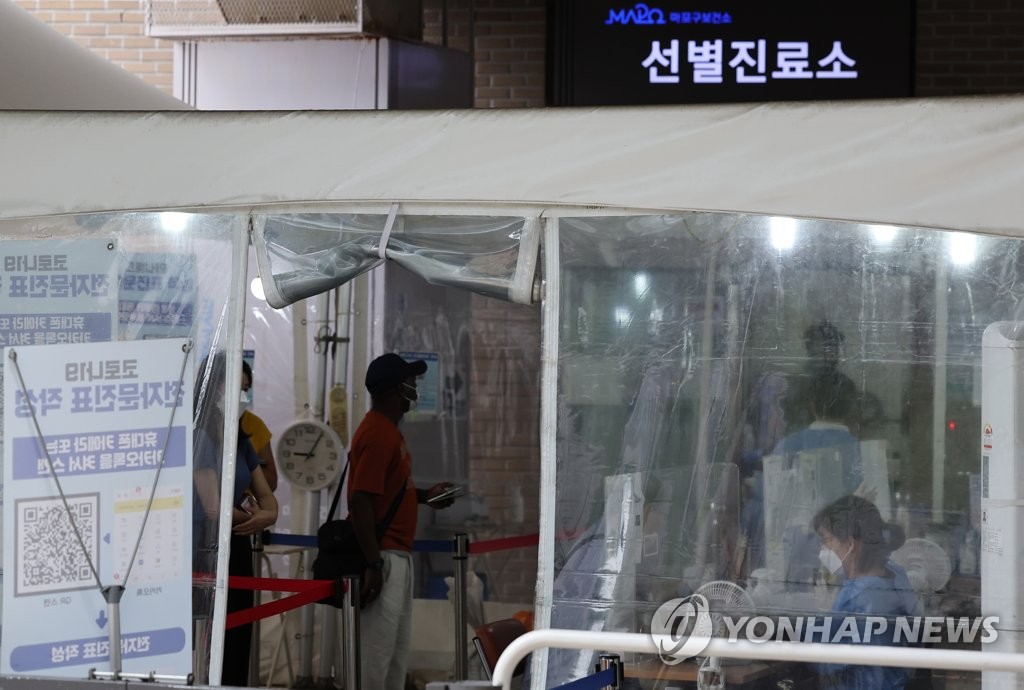 8月5日，在设于首尔市麻浦区卫生站的新冠筛查诊所，市民排队待检。 韩联社