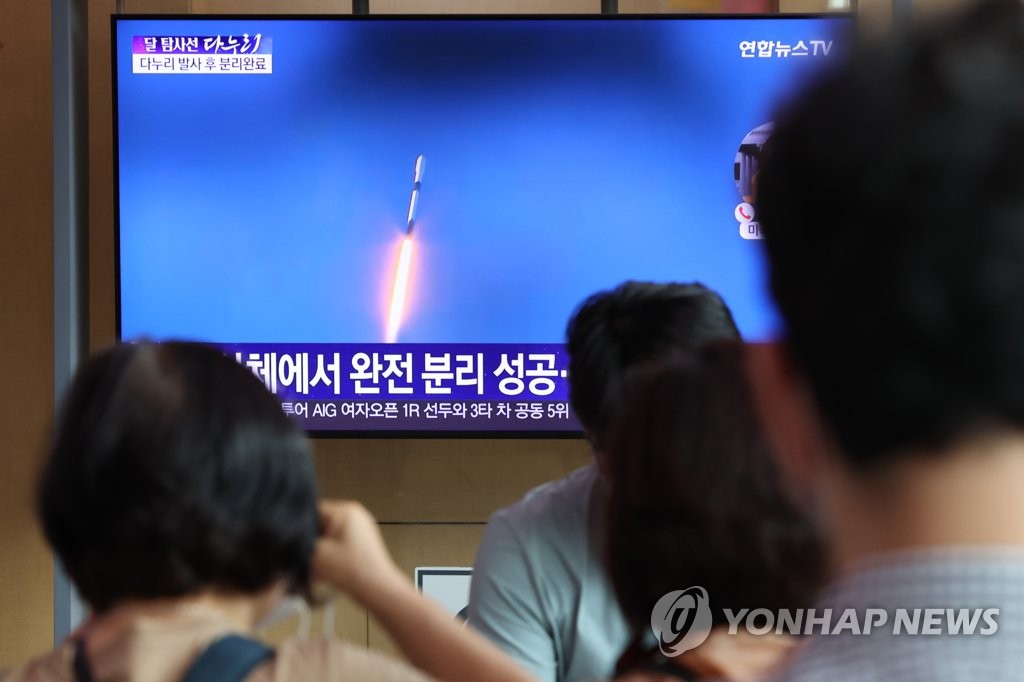 8月5日上午，在首尔站候车室，旅客收看韩国首架月球轨道探测器发射升空的电视新闻。 韩联社