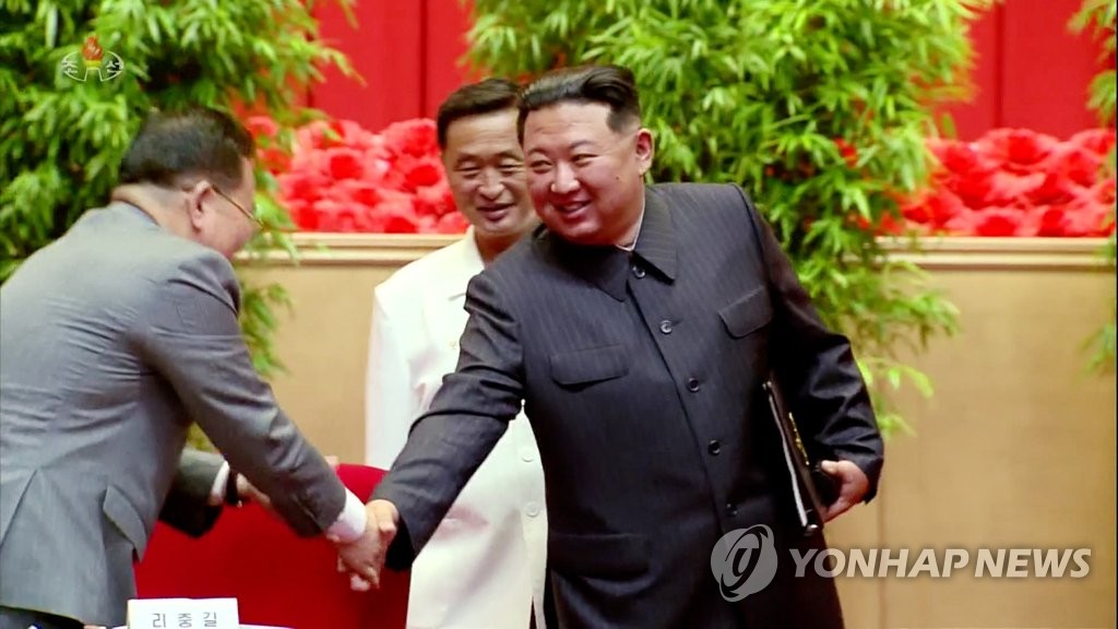 金正恩与防疫首长李忠吉握手