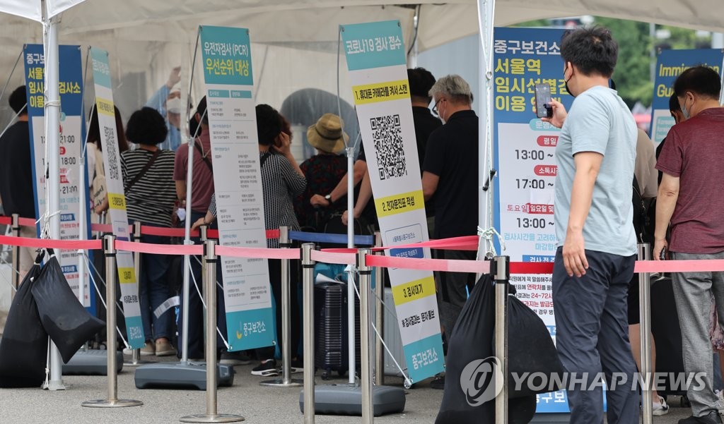 资料图片：8月14日，在设于首尔站的筛查诊所，市民排队等待检测。 韩联社