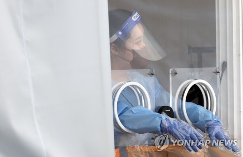 资料图片：8月14日，在设于首尔站的筛查诊所，医护人员准备采样。 韩联社