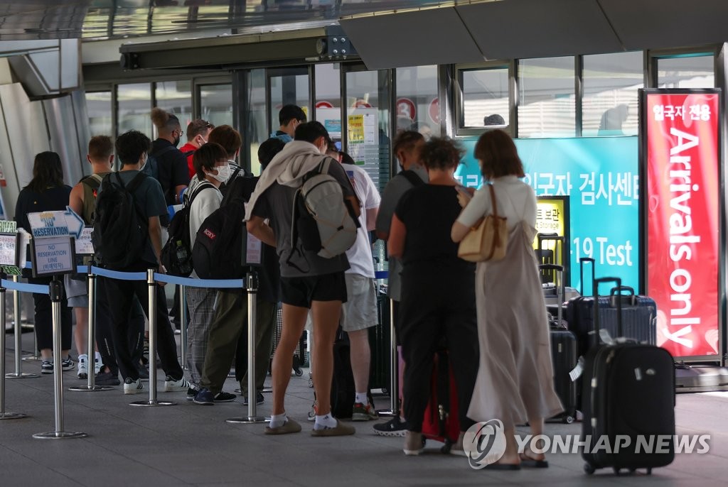 8月16日下午，在仁川国际机场第一航站楼入境核酸检测中心，旅客排队采样。 韩联社