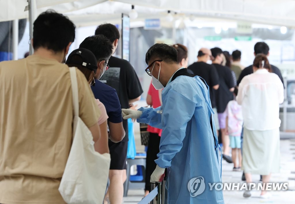 8月19日，在首尔麻浦区卫生站的新冠筛查诊所，市民们排队待检。 韩联社