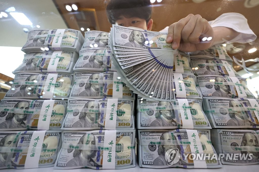 资料图片：8月24日，在位于首尔中区的韩亚银行总行，工作人员清点美元钞票。 韩联社