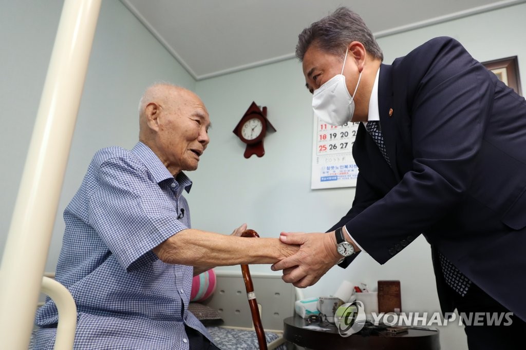 资料图片：9月2日，在光州市，韩国外长朴振（右）会见二战时期日本强征劳工受害者。 韩联社