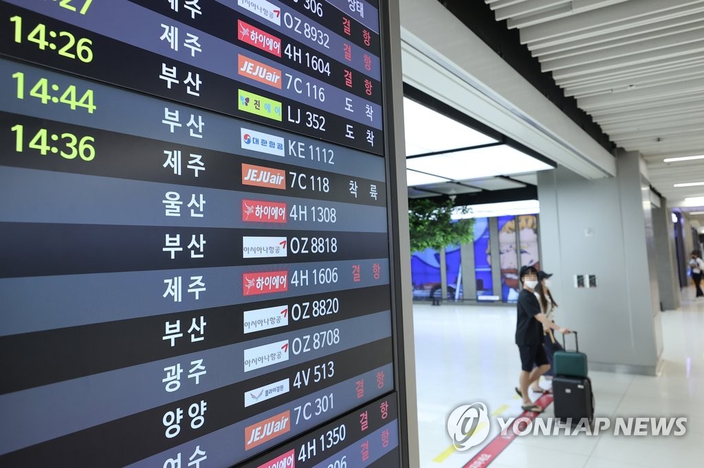 资料图片：9月5日，受今年第11号台风“轩岚诺”的影响，大批航班取消。图为金浦机场场候机楼的电子屏幕上显示有不少航班取消。 韩联社