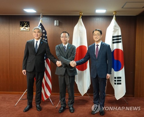9月7日，在日本东京外务省，韩国外交部韩半岛和平交涉本部长金健（右）、美国国务院对朝政策特别代表星·金（左）、日本外务省亚大局局长船越健裕举行会晤。图为韩美日对朝代表在会谈前握手合影。 韩联社