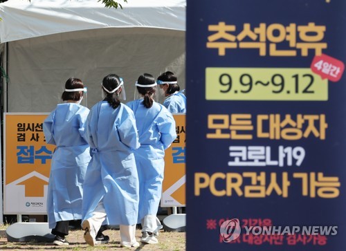 资料图片：9月7日，一处新冠临时筛查诊所挂出中秋期间提供核酸检测服务的海报。 韩联社