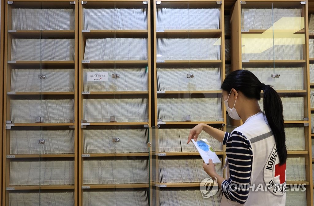 资料图片：2022年9月8日，在首尔市中区的大韩红十字社离散家属办事处，职员正在查阅韩朝离散家属视频信件材料。 韩联社