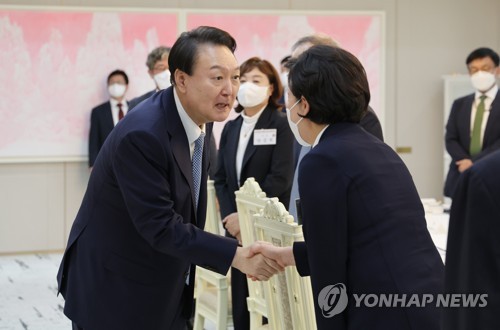 9月14日，在首尔市龙山总统府，尹锡悦（左）同国民力量半导体产业竞争力强化特别委员会成员们举行午餐会。图为尹锡悦（左）与特委会主席梁香子握手。 韩联社