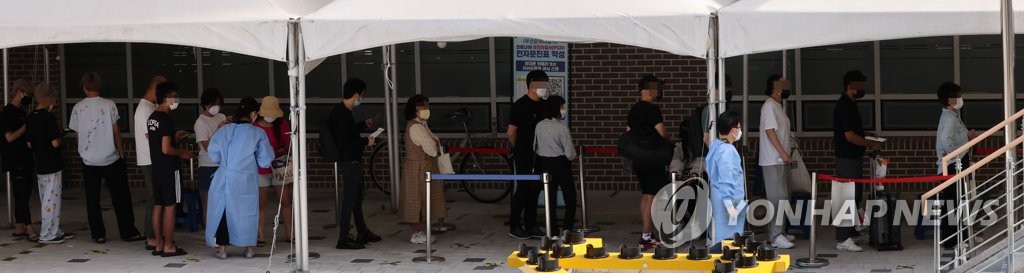 资料图片：排队等候核酸检测。 韩联社