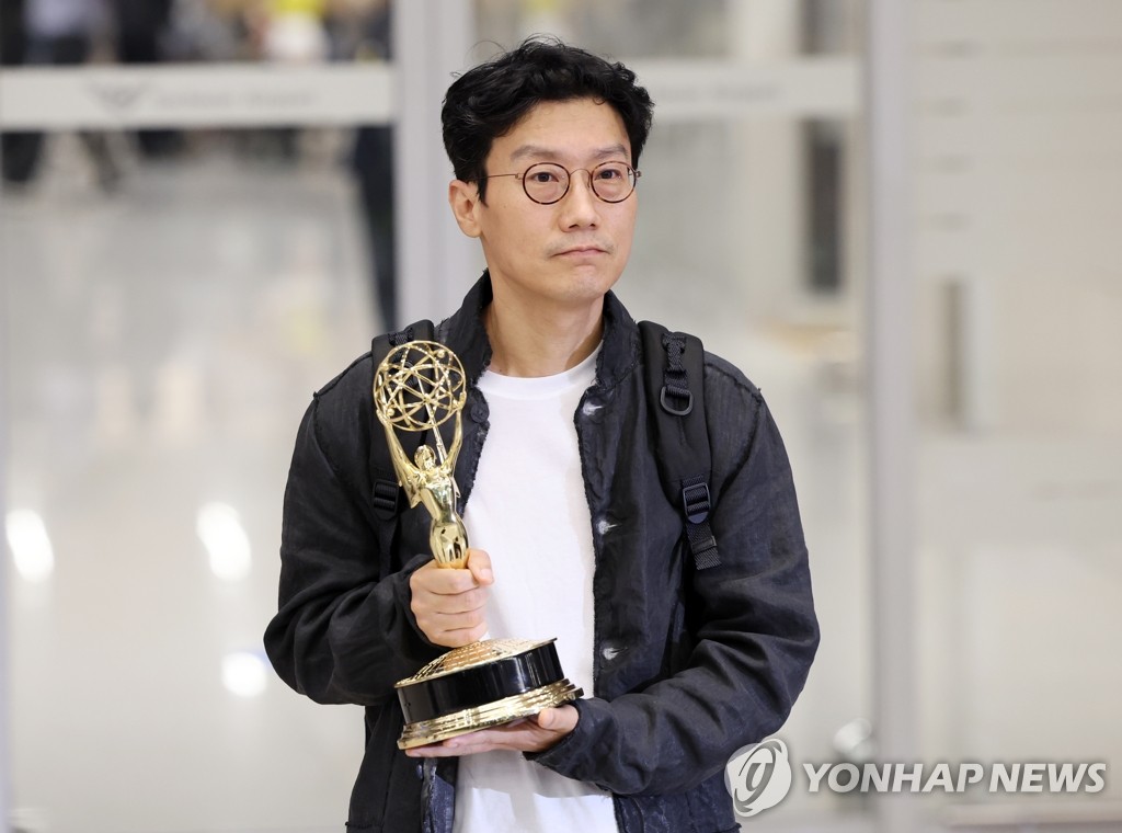 9月15日，在仁川国际机场，韩剧《鱿鱼游戏》导演黄东赫举着艾美奖奖杯供记者拍照。 韩联社
