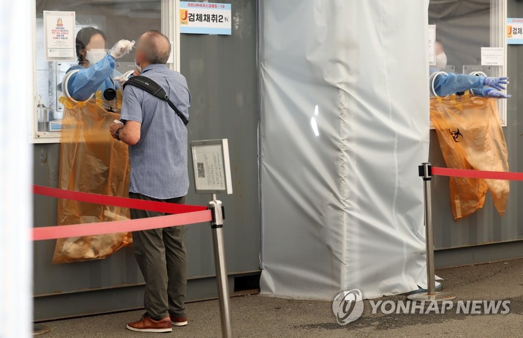 资料图片：9月18日下午，在首尔市的临时核酸检测点，医务人员正在采样。 韩联社