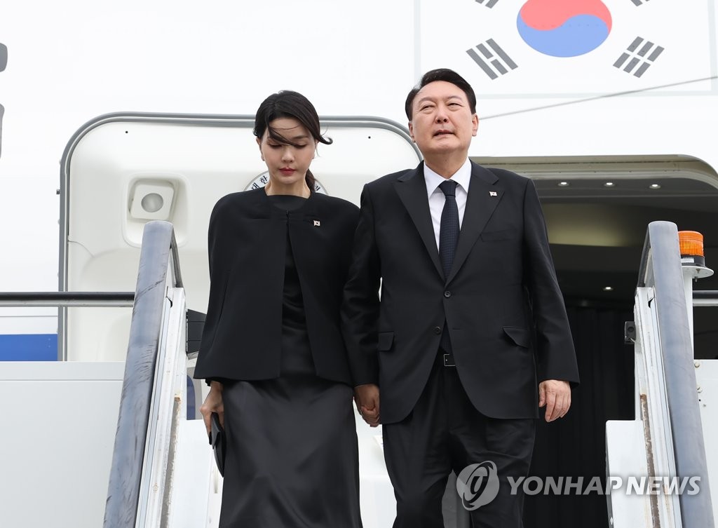 资料图片：当地时间9月18日，韩国总统尹锡悦（右）和夫人金建希乘坐总统专机空军一号抵达英国伦敦斯坦斯特德机场。 韩联社