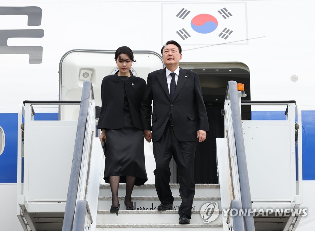 资料图片：当地时间9月18日，在英国伦敦斯坦斯特德机场，韩国总统尹锡悦（右）和夫人金建希走下总统专机“空军一号”。 韩联社