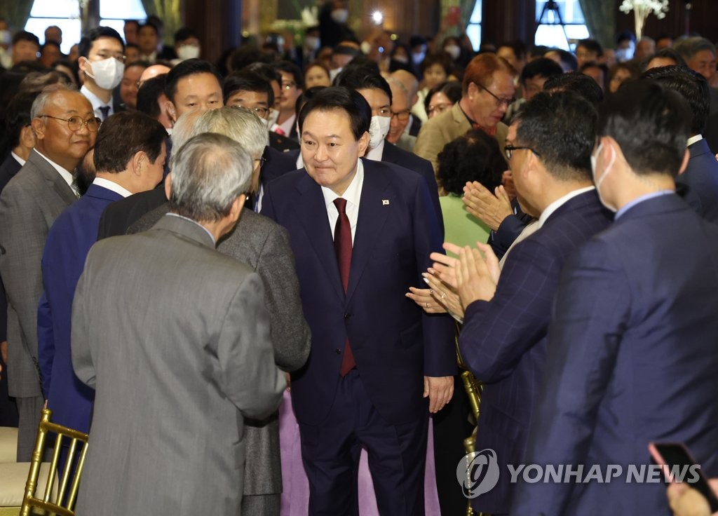 当地时间9月20日，在纽约，韩国总统尹锡悦（系暗红色领带）与韩侨握手致意。 韩联社