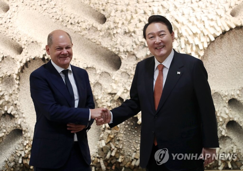 资料图片：当地时间2022年9月21日，在位于美国纽约的韩国驻联合国代表部，韩国总统尹锡悦（右）和德国总理朔尔茨举行会谈。图为双方握手合影留念。 韩联社