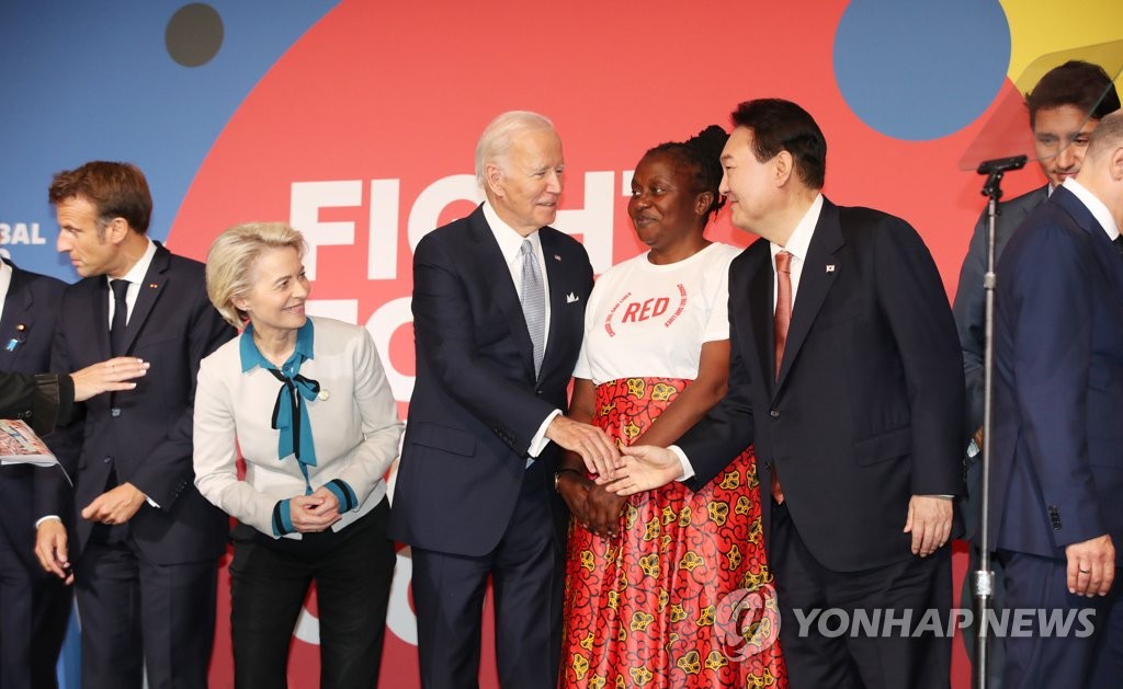 当地时间9月21日，在美国纽约，韩国总统尹锡悦（右二）在“全球基金第七次充资大会”的拍照环节上与美国总统拜登（左三）握手。 韩联社