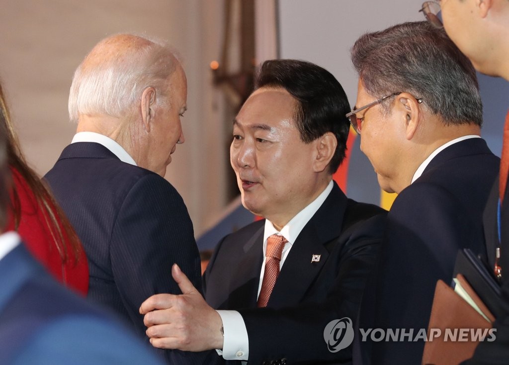 当地时间9月21日，在美国纽约，韩国总统尹锡悦（右）在“全球基金第七次充资大会”的拍照环节中与美国总统拜登（左）扶臂交谈。 韩联社
