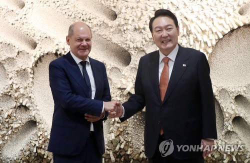 资料图片：当地时间2022年9月21日，在位于美国纽约的韩国驻联合国代表部，韩国总统尹锡悦（右）和德国总理朔尔茨举行会谈。图为双方握手合影留念。 韩联社