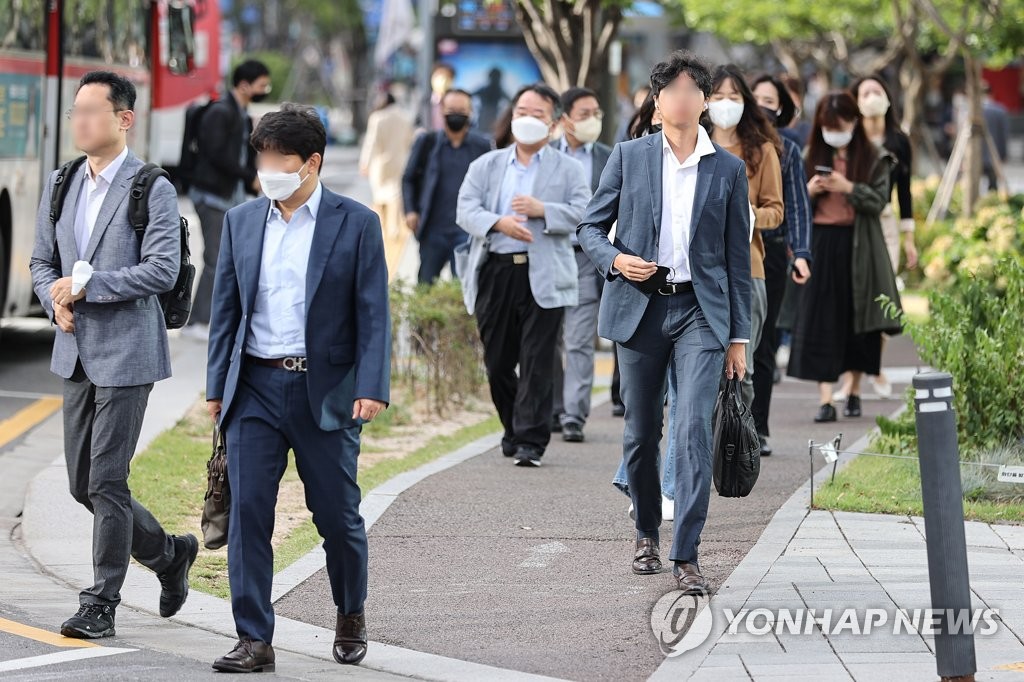 9月26日上午，在首尔光化门地铁站附近，人们穿着外套赶去上班。韩国从当天起时隔1年零5个月全面解除户外戴口罩义务。 韩联社