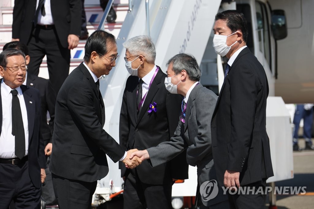 9月27日上午，在东京羽田机场，韩悳洙（左）下机后与前来迎接的人员握手。 韩联社