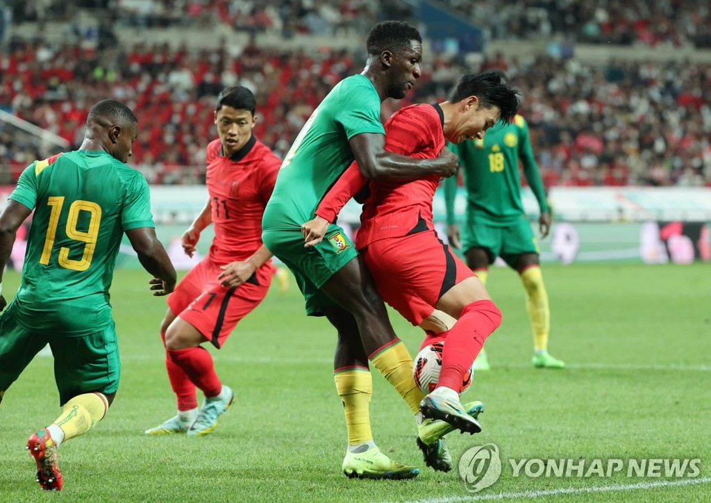 9月27日下午，在首尔市麻浦区首尔世界杯体育场，韩国男足与喀麦隆队进行热身赛。图为孙兴慜（右一）与对手争球。 韩联社
