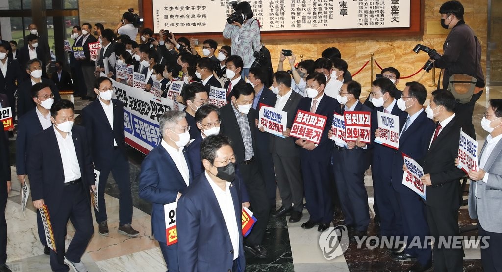 9月29日，在韩国国会，执政的国民力量党籍议员们举牌抗议在野党提案建议免除朴振的外长职务。 韩联社/国会摄影记者团