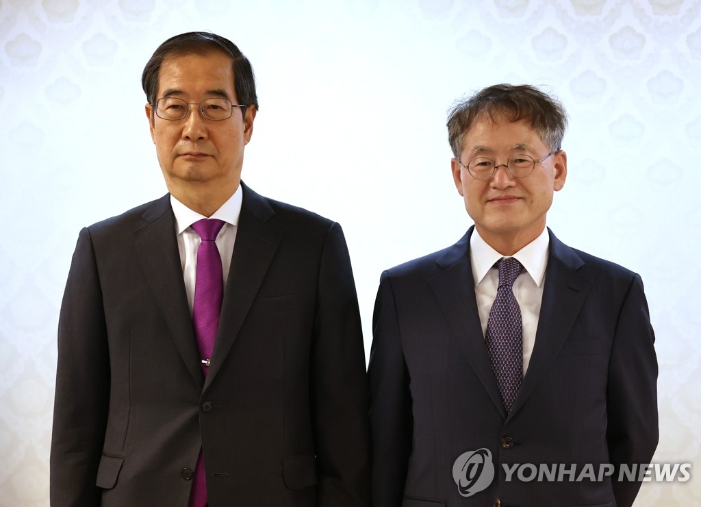 资料图片：韩国国务总理韩悳洙（左）去年向崔京林颁发釜山世博会申委会特别顾问任命书并合影留念。 韩联社