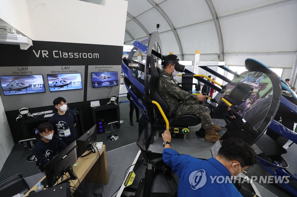 10月7日，在位于忠清南道的陆海空军总部鸡龙台，2022鸡龙世界军事文化博览会开幕。图为访客们在四次产业融合馆体验虚拟模拟器。 韩联社