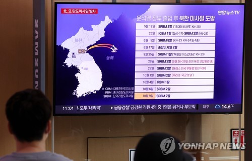 资料图片：10月9日，在首尔火车站候车室，市民收看有关朝鲜发射弹道导弹的新闻。 韩联社