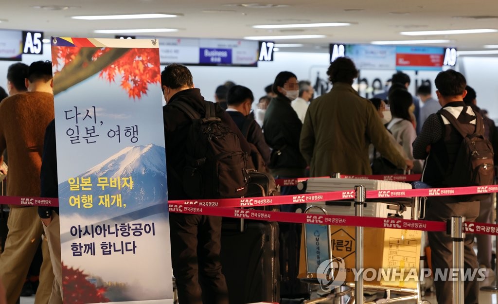 10月11日，在金浦机场，旅客们等待办理飞往羽田机场的登机手续。 韩联社