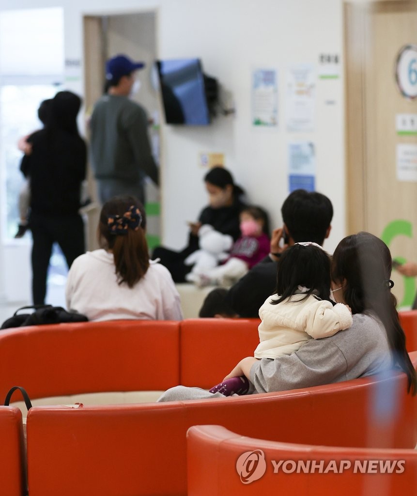 资料图片：10月18日，在首尔城北区一家儿科医院，不少家长带着孩子就医。据疾病管理厅14日发布的消息，今年秋冬季出现新冠疫情与流感叠加流行风险正日趋增大。 韩联社