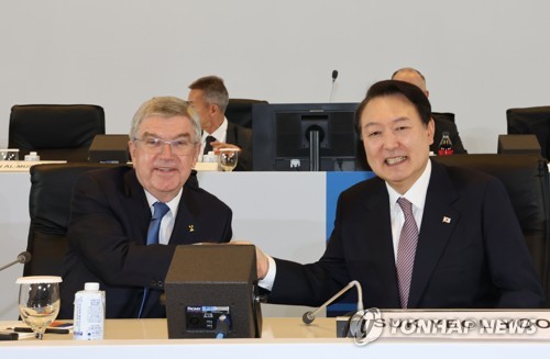 10月19日，在首尔国际会展中心（COEX），韩国总统尹锡悦（右）出席第26届国家和地区奥林匹克委员会协会（ANOC）大会。图为尹锡悦与国际奥林匹克委员会（IOC）托马斯·巴赫合影留念。 韩联社