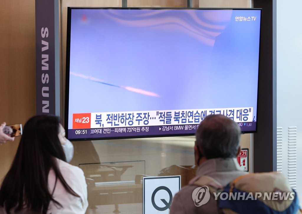 资料图片：10月19日，在首尔火车站，市民观看有关朝鲜炮击挑衅的电视新闻。 韩联社
