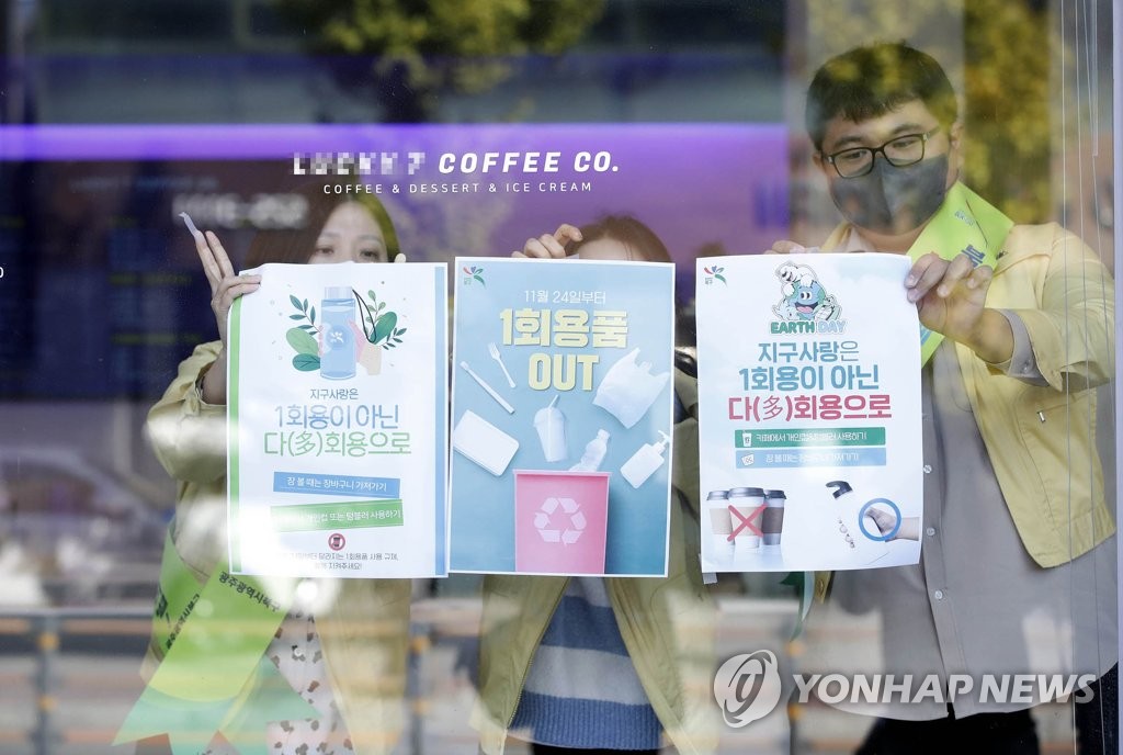10月24日，在光州北区一家咖啡店，区政府工作人员清张贴禁塑宣传海报。 韩联社/光州北区供图（图片严禁转载复制）