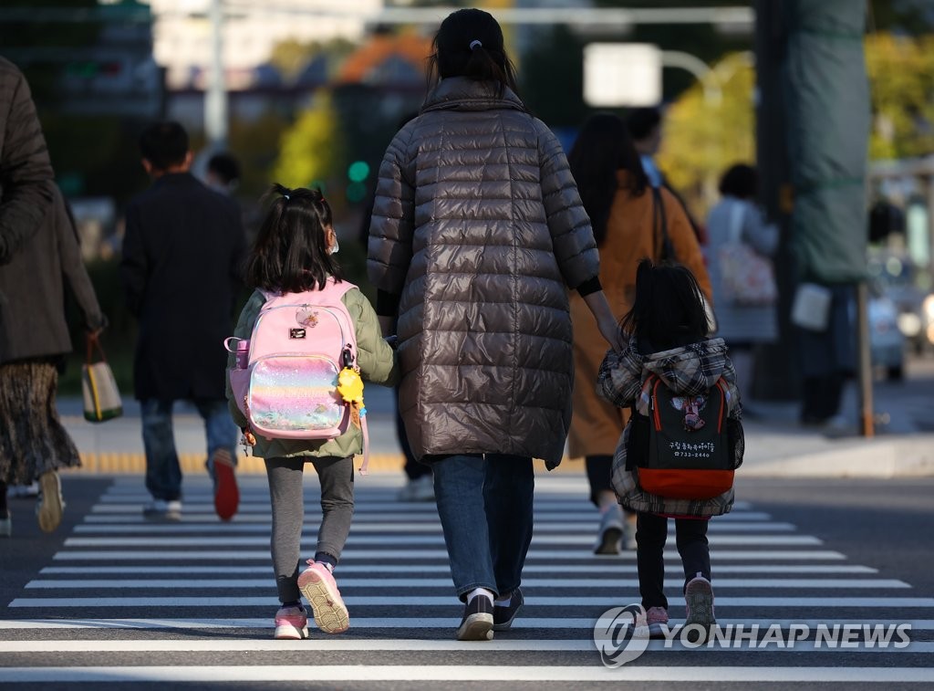 资料图片：一位母亲送孩子上学。 韩联社