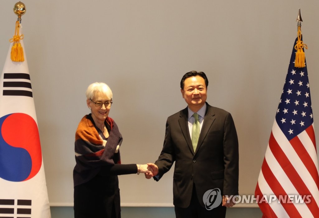 10月25日，在位于东京的韩国驻日大使馆大楼，韩国外交部第一次官（副部长、右）赵贤东和美国常务副国务卿温迪·舍曼开会。图为双方合影留念。 韩联社