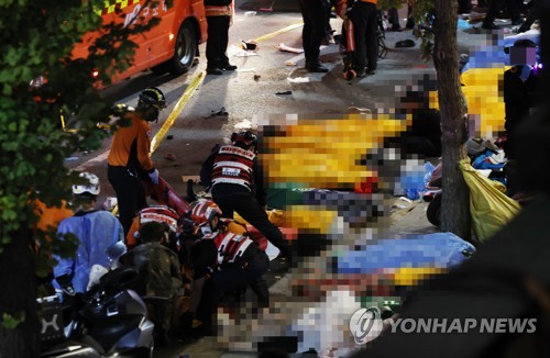 10月29日夜间，在首尔市龙山区梨泰院洞踩踏事故现场，救援人员正在抢救伤员。 韩联社