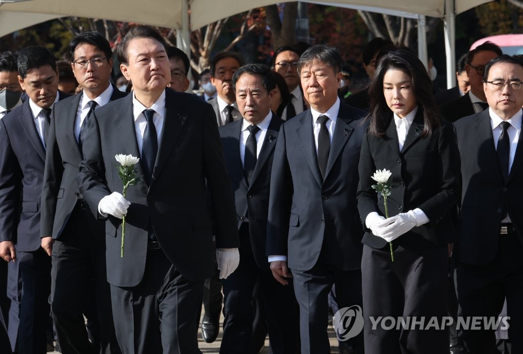 10月31日上午，在首尔广场的梨泰院踩踏事故遇难者吊唁堂，韩国总统尹锡悦（前排左）与夫人金建希（前排右）献花致祭。 韩联社