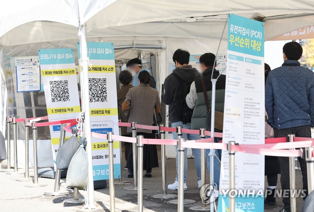 资料图片：11月6日，在设于首尔站广场的新冠筛查诊所，市民们排队待检。 韩联社
