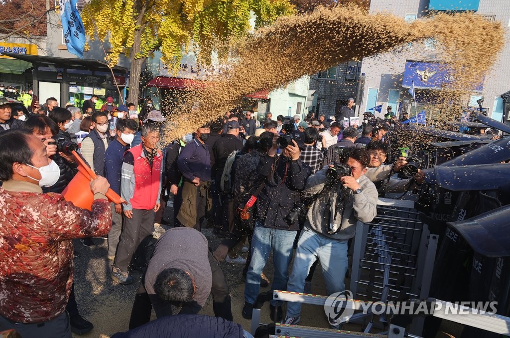 나락 뿌리며 시위 벌이는 농민들