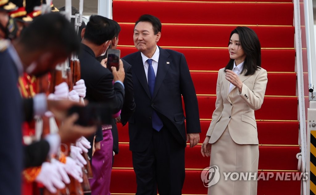 当地时间11月11日，韩国总统尹锡悦（左）和妻子金建希乘专机飞抵柬埔寨金边。 韩联社