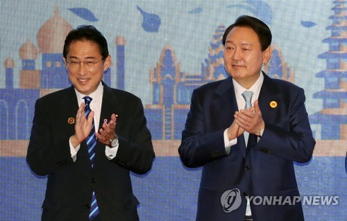 资料图片：当地时间11月12日，韩国总统尹锡悦（右）在柬埔寨金边出席东盟与韩中日（10+3）领导人会议。图为尹锡悦（右）与日本首相岸田文雄参加集体合影环节。 韩联社