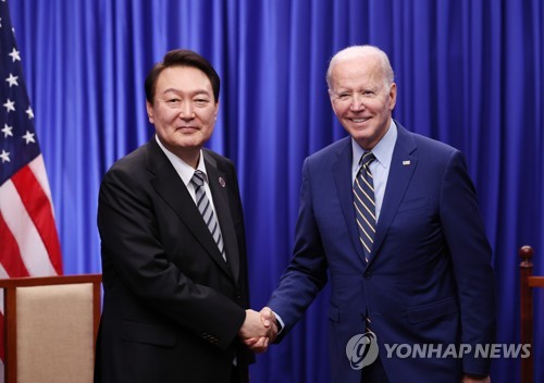 资料图片：当地时间2022年11月13日，在柬埔寨金边，韩国总统尹锡悦（左）和美国总统拜登举行会谈。图为双方在会谈前合影留念。 韩联社