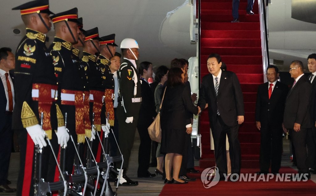 资料图片：当地时间11月13日，韩国总统尹锡悦（居中）乘坐总统专机“空军一号”抵达印度尼西亚巴厘岛国际机场，准备出席二十国集团（G20）峰会。 韩联社