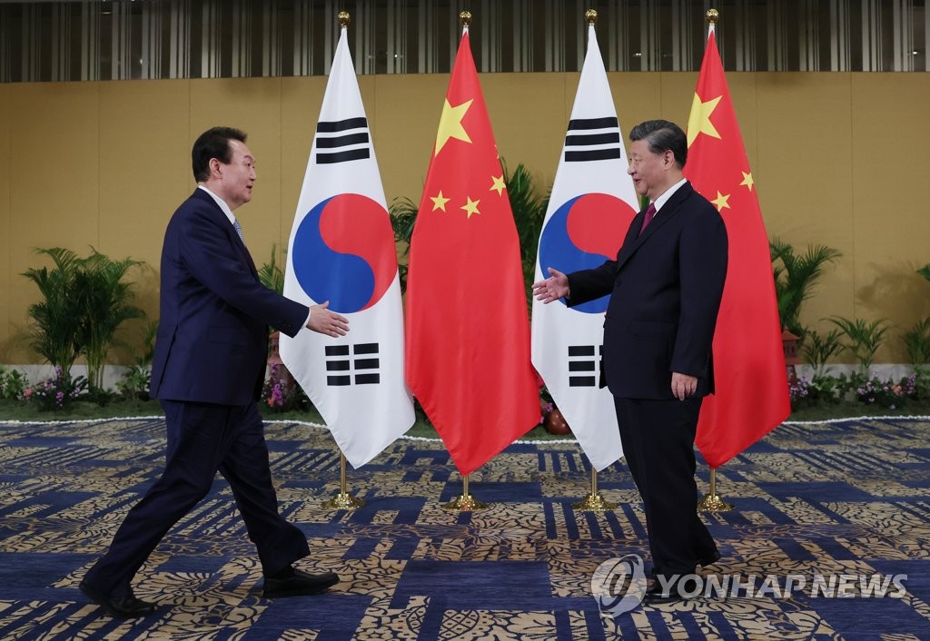 当地时间11月15日，在印尼巴厘岛的一家酒店，韩国总统尹锡悦（左）和中国国家主席习近平举行会谈。图为双方在会谈之前握手致意。 韩联社