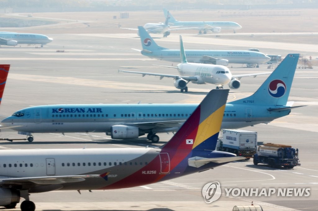 资料图片：首尔金浦机场的大韩航空和韩亚航空客机 韩联社