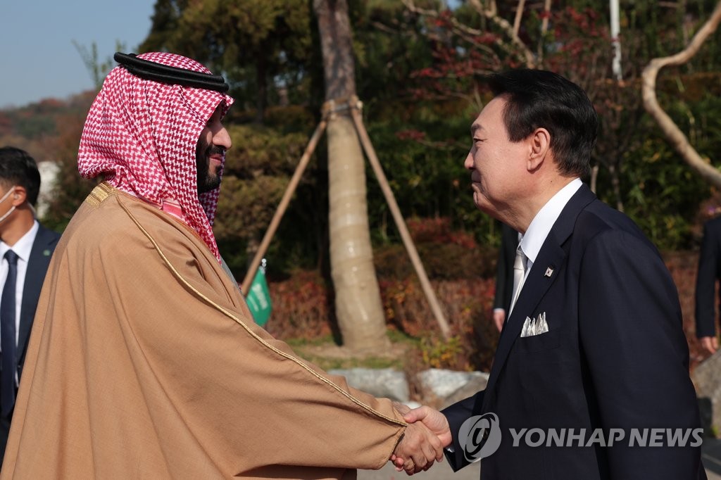 11月17日，韩国总统尹锡悦（右）与沙特王储本·萨勒曼举行会谈前亲切握手。 韩联社/总统室供图（图片严禁转载复制）