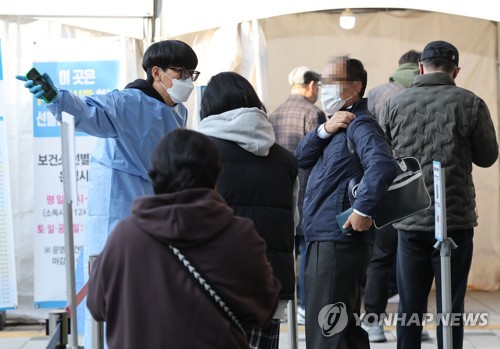 资料图片：11月21日，在设于首尔市芦原区卫生站的新冠临时筛查诊所，医务人员正指引市民做核酸检测。 韩联社